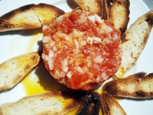 Ensaladita de tomate fresco con bacalao, cebolleta y tostas de pan casero